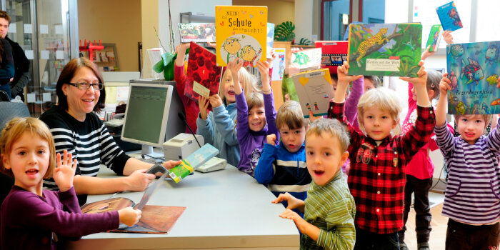 Kinder zeigen ihre ausgeliehenen Bücher