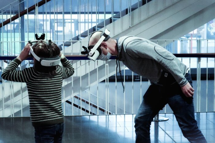 Kind und Mann testen VR-Brillen