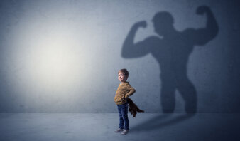 Kind mit Schatten eines Bodybuilders