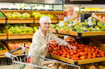 Frau kauft Tomaten im Supermarkt