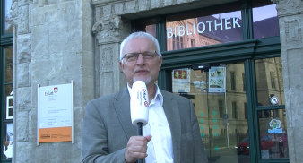 Foto: Bibliotheksdirektor Kusber lädt in die Bibliothek am Domplatz und in die Kinder- und Jugendbibliothek Marktstraße 21 ein © Stadtverwaltung Erfurt Mann spricht ins Mikrofon.