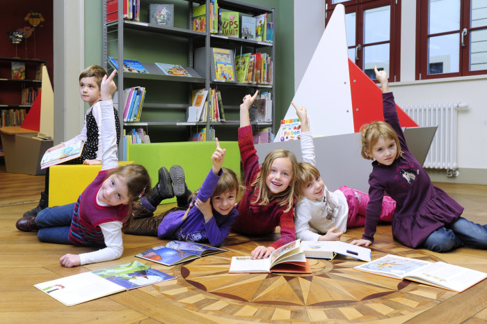 Eine Gruppe Kinder freut sich über ihre Lektüre.