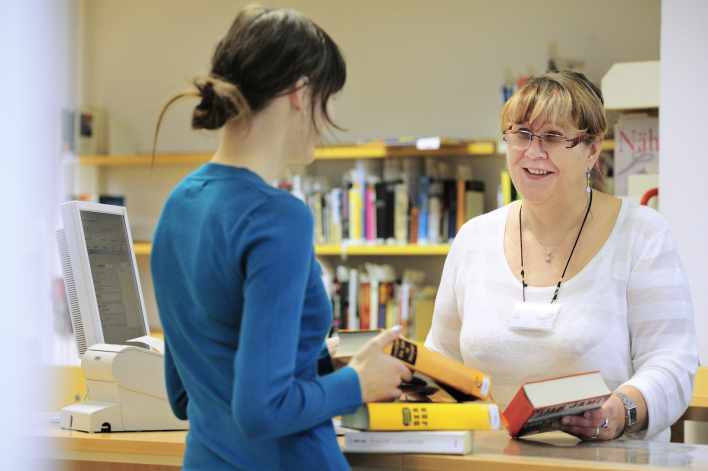 Foto: Ausleihe in der Hauptbibliothek © Landeshauptstadt Erfurt, Stadtverwaltung Eine Bibliothekarin verbucht ausgeliehene Medien.