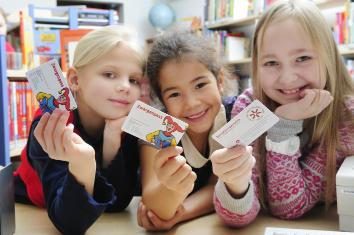 Foto: Kinder mit Benutzerausweisen © Landeshauptstadt Erfurt, Stadtverwaltung Drei Kinder zeigen lächelnd ihre Benutzerausweise in die Kamera