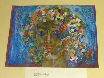 Die farbenfrohe Grafik „Flora" zeigt ein mit Blumen geschmückten Frauenkopf.