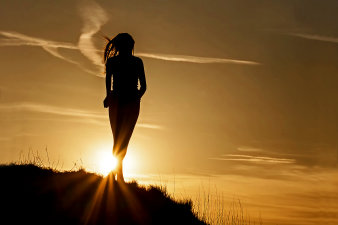 Foto: VHS-Kurs: Hatha Yoga am Mittag © Stadtverwaltung Erfurt/Grit Kästner Junges Mädchen als Silhouette auf einem Berg im Sonnenuntergang.