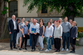 Teamfoto der Mitarbeitenden der Volkshochschule Erfurt mit Oberbürgermeister Andreas Bausewein und Bürgermeisterin Tamara Thierbach im Hof der Volkshochschule in der Schottenstraße.
