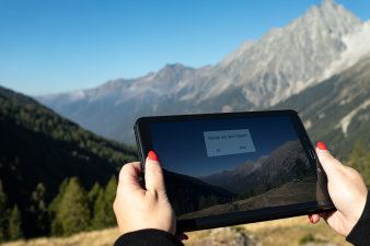 Foto: VHS-Kurs: iPad © Stadtverwaltung Erfurt/Grit Kästner Vor der Landschaft Südtirols wird ein iPad gehalten