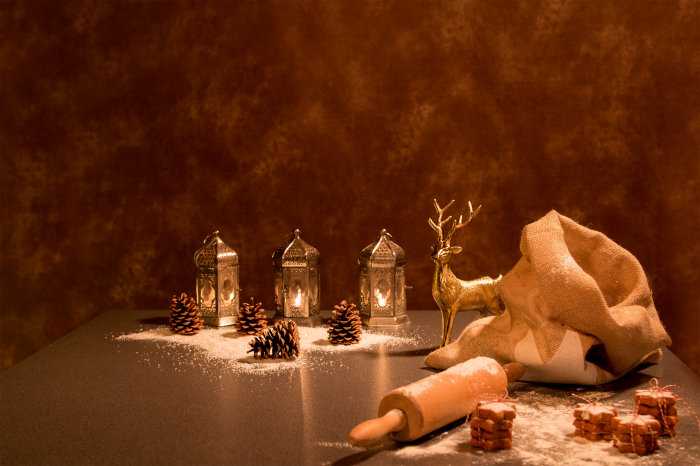 Ein Tisch im Advent mit Plätzchen, Mehl, Tannenzapfen und Kerzen.