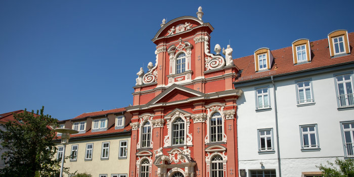 Kirchenfassade inmitten einer Häuserzeile.