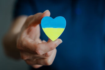 Foto: Hilfe Ukraine © Rachbauer/123RF.com Ein Holzherz in der Hand, welches in den ukrainischen Farben hellblau und gelb bemalt ist.