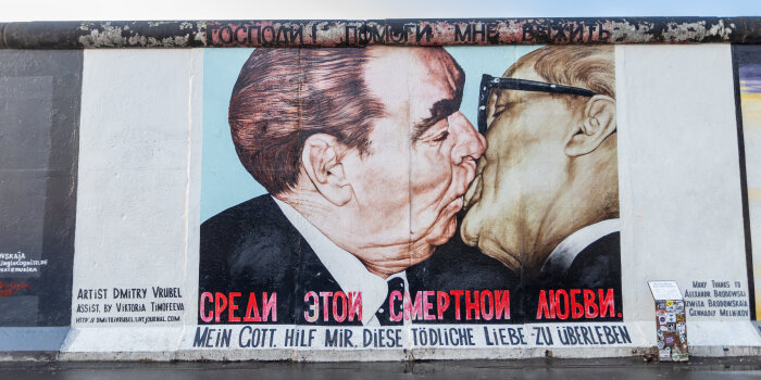 Zeigt einen Ausschnitt der Reste der Berliner Mauer mit Graffiti des Bruderkusses zwischen Breschnew und Honecker.