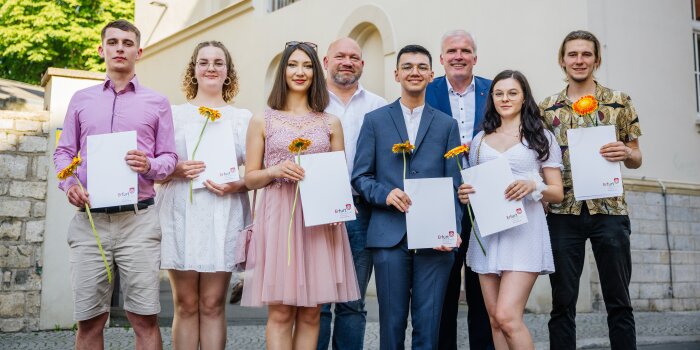 sechs Personen halten ein Abschlusszeugnis in der Hand