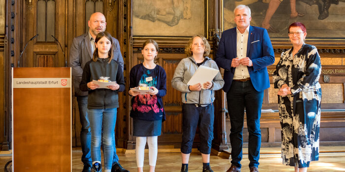 drei Erwachsene und drei Kinder stehen in einer Reihe