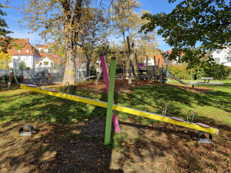 Spielplatz mit einer bunten Spielanlage aus Holz