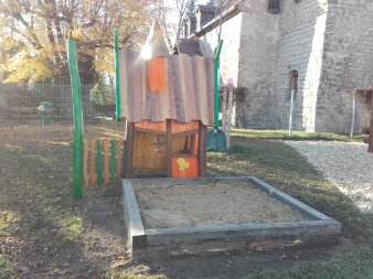 Sandkasten mit Spielhaus auf einem Spielplatz