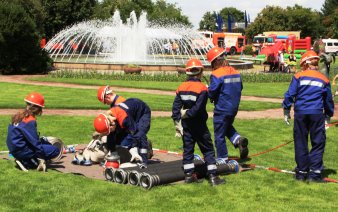 Kinder der Jugendfeuerwehr beim Wettkampf auf einer Wiese