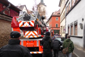 Drehleiterfahrzeug der Feuerwehr in einer engen Straße von Pkw behindert