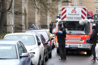 Drehleiterfahrzeug der Feuerwehr in einer engen Straße von Pkw behindert