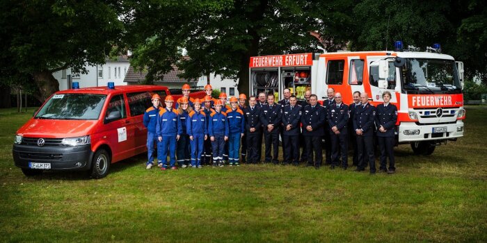 Gruppenfoto von Jugendlichen und Erwachsenen Kameraden vor Feuerwehrautos