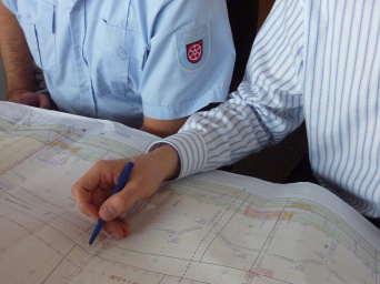 Ein Mitarbeiter der Feuerwehr prüft mit dem Fachplaner ein Detail im Genehmigungsplan.