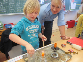 Frau Nadja Götze erklärt dem Schüler Jason Hahn der Klasse 2c Grundschule 25 Astrid Lindgren dem Umgang mit Feuer am Beispiel einer brennenen Kerze