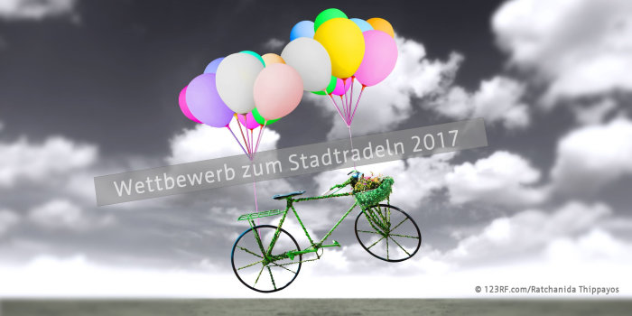 Fotoinstallation: Luftballons schweben mit einem angehängten Fahrrad durch die Wolkenlandschaft.