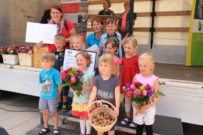 Das Bild zeigt die Verleihung des 1. Preises an die Erzieherinnen der Kindertagesstätte "Glühwürmchen" mit der zugehörigen Kindergartengruppe. 