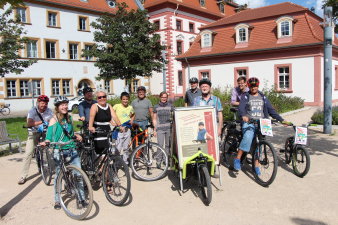 Radfahrer stehen vor einem historischen Gebäude.