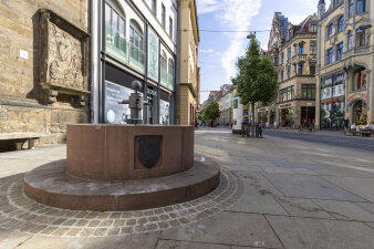 steinerner Trinkbrunnen auf einem Gehweg