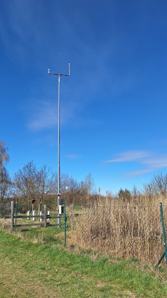 Foto: Klimastation auf der Fuchsfarm © Stadtverwaltung Erfurt Auf der Wiese steht ein langer Mast zum Messen der Temperatur, Luftfeuchtigkeit, Windrichtung, Windgeschwindigkeit.