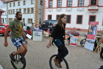 Zwei Einradfahrer vor Ständen zum Tag der Nachhaltigkeit