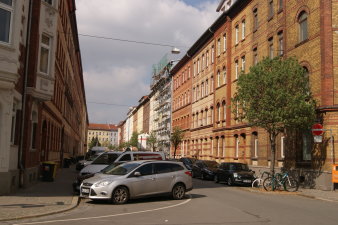 Straßenzug mit Autos und Bäumen