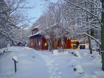 Winterlandschaft im Sonnenschein mit dem Gebäude der Fuchsfarm