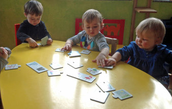 Kinder sitzen gemeinsam an einem Tisch und versuchen ein Puzzle zu lösen