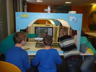 Foto: erzieherischer Kinder- und Jugendschutz © Stadtverwaltung Erfurt Jungs sitzen mit einer Betreuerin vor einem PC und betrachten das Kinderspiel auf dem Monitor