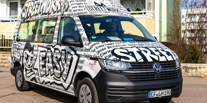 Foto: neuer Bus der Streetworker © Stadtverwaltung Erfurt Der neue Streetworkbus, gestaltet in schwarz weißen Worten und Comicfiguren, steht vor einem Wohnblock.