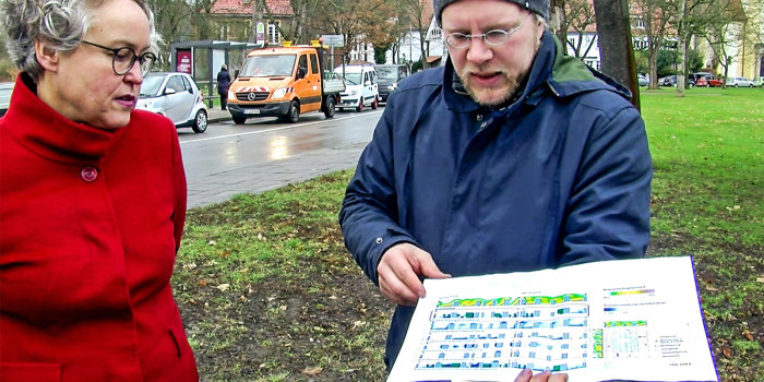 Foto: Umweltbeigeordnete Kathrin Hoyer und Jens Düring vom Umwelt- und Naturschutzamt hatten zum Vor-Ort-Termin zum Baumstandort Straße des Friedens / Ecke Espachstraße eingeladen. © Stadtverwaltung Erfurt / V. Gürtler eine Dame und ein Herr in der Stadt mit einem farbigem Plan in der Hand