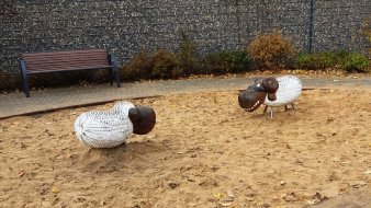 großer Sandkasten mit zwei Schafen aus Holz zum sitzen