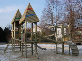 große Sandfläche mit Kletter- und Rutschenturm aus Holz