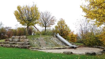 Rutsche aus Metall an einem mit Steinen befestigten Hang