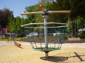 große Sandfläche mit großem Korb aus Seilen zum Drehen
