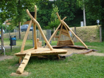 eckiger Sandkasten mit Holzpfosten zum Klettern und Sitzen