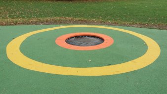 im grünen Boden eingefasstes Trampolin