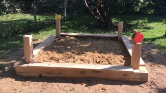 kleiner viereckiger Sandkasten aus Holz