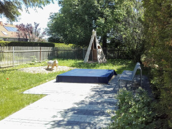 Spielplatz mit abgedecktem Sandkasten, Holzpferd und Tipi-Zelt