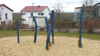 große runde Sandfläche mit blauem Reck