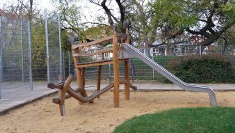 Sandfläche mit Kletterturm aus Holz und Rutsche