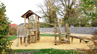 große Sandfläche mit Kletterturm aus Holz