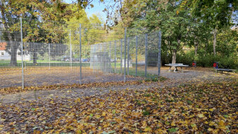 ein eingezäunter Bolzplatz, daneben eine Tischtennisplatte